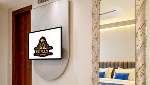 A modern hotel room with a large mirror, a television mounted on the wall, and a neatly made bed. - Anu Plaza-5Mins from Connaught Place (New Delhi)
