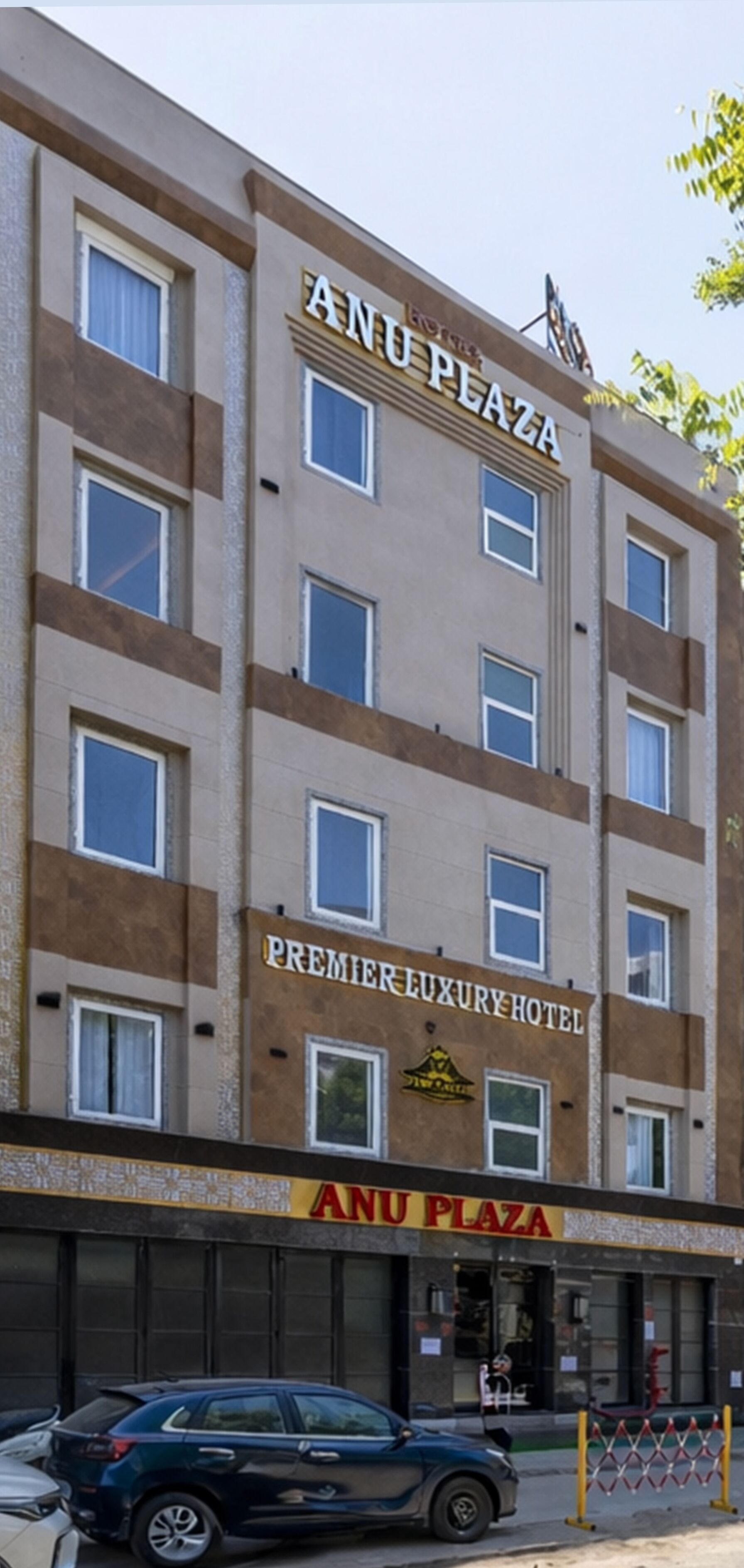 Un immeuble à plusieurs étages portant les inscriptions « ANU PLAZA » et « PREMIERE LUXURY HOTEL ».