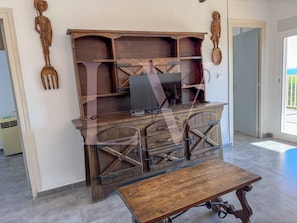 A rustic wooden desk with a laptop, a small table, and decorative wooden figures. - LV WEST INDIES (Salou)