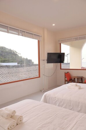 Habitación cuádruple Premier, vistas parciales al mar | Minibar, escritorio, wifi gratis y ropa de cama