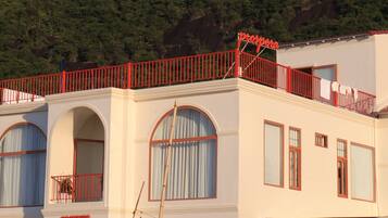A building with a red balcony, arched windows, and a sign that reads 'prospera'.