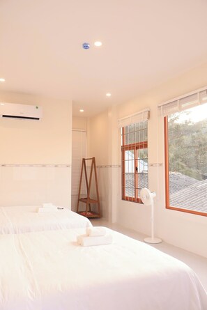 Habitación cuádruple Premier, vistas parciales al mar | Minibar, escritorio, wifi gratis y ropa de cama