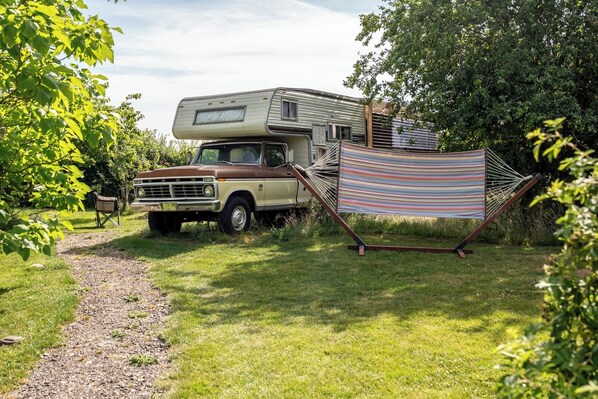 A vintage truck parked beside a mobile home with a hammock. - 1 Bed Vehicle Luxury Camper -hot Tub, Pets - Willy (Skegness)