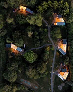 An aerial view of a residential area with multiple houses connected by pathways, surrounded by dense trees. - 1 Bed Vehicle Luxury Camper -hot Tub, Pets - Willy (Skegness)
