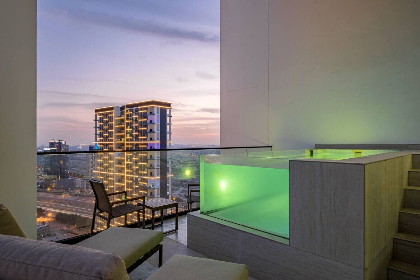 A modern apartment with a balcony, a pool area, and a view of a cityscape.