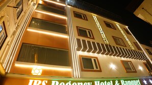 Un hotel de varios pisos con señalización iluminada para JBS Regency Hotel & Banquet.