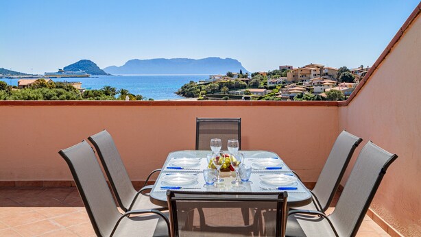 Ein Tisch für zwei Personen mit Blick auf das Meer und die Hügel.