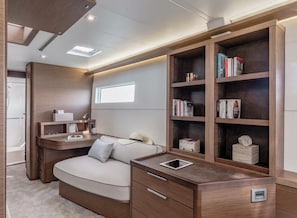 Ein modernes, kompaktes Schlafzimmer mit integriertem Schreibtisch, Nachttischen und Bücherregal.
