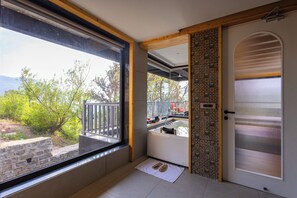 A room with a large window, a door with a decorative pattern, and a view of greenery outside. - ELIVAAS Prive The Retreat 4 BHK Villa  (Kasauli)