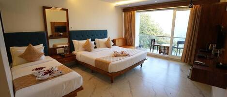 A hotel room with two beds, a balcony, a TV, and a desk.