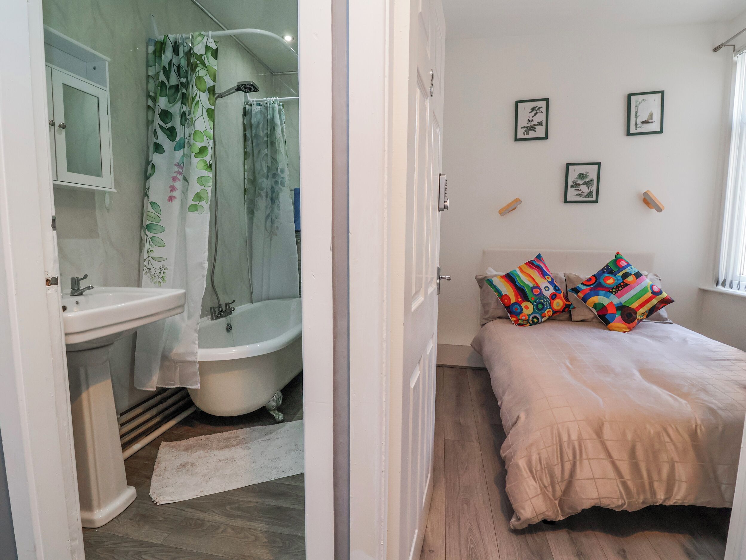 Een slaapkamer met een bed, kussens, een nachtkastje en een raam.