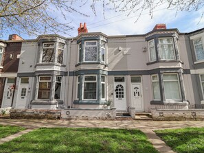 A row of townhouses with bay windows, a brick chimney, and a small front garden. - Ince Lodge (Liverpool)
