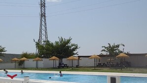 A swimming pool with a white fence, umbrellas, and a picnic area in the background. - Roof Terrace - Pet - Parking - Pool- Sleeps 2 (Rute)