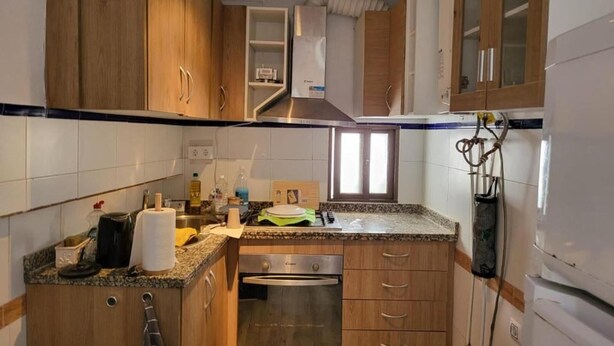 A kitchen with wooden cabinets, a stainless steel range hood, a built-in oven, and a granite countertop. - Roof Terrace - Pet - Parking - Pool- Sleeps 2 (Rute)