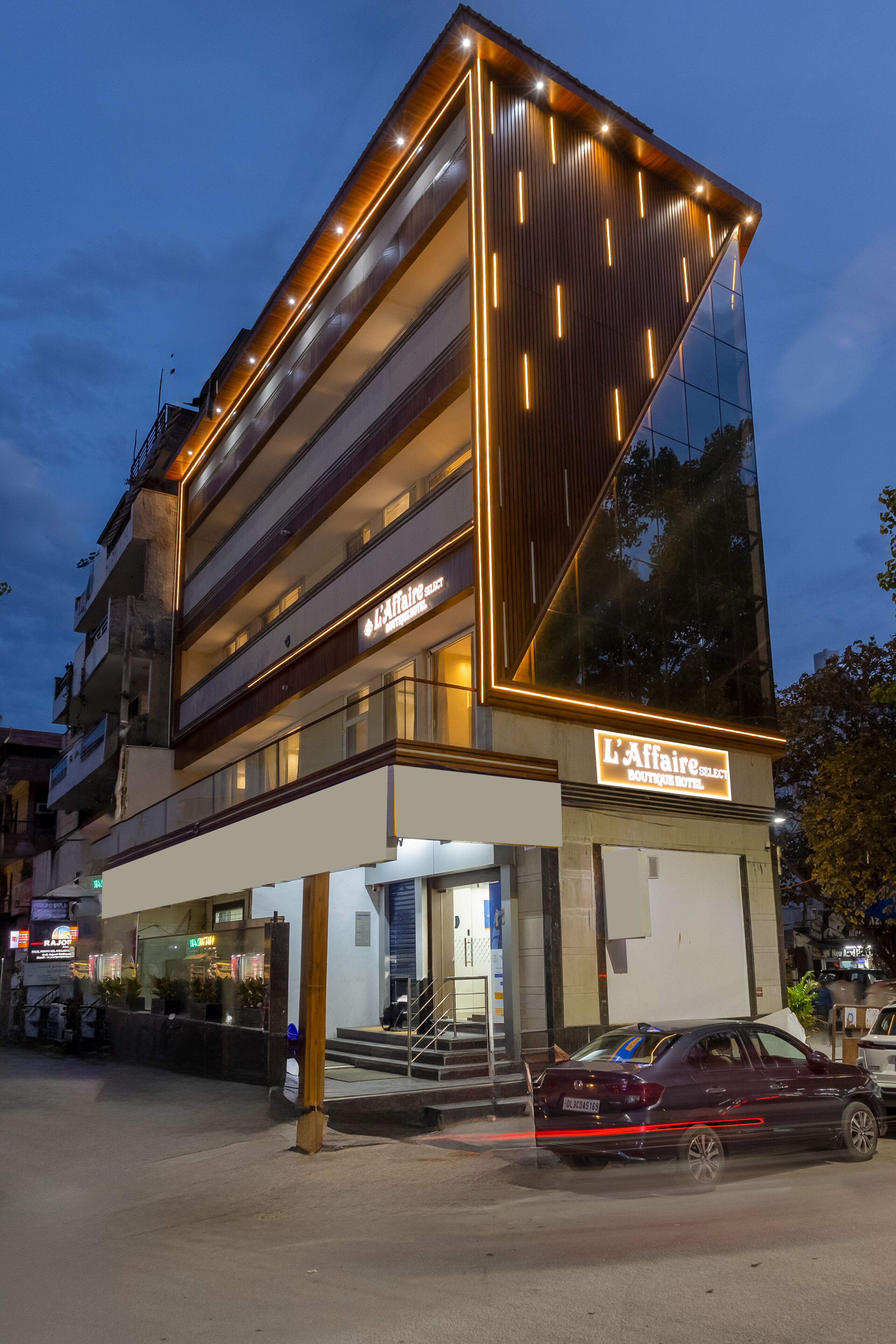 A modern hotel with a prominent sign, a glass facade, and a visible entrance.
