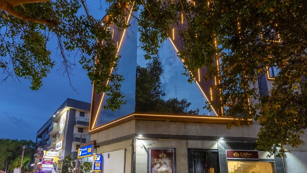 A building with a modern design, featuring a prominent triangular structure and a well-lit entrance. - Hotel Laffaire Select Near Rajori Metro (New Delhi)