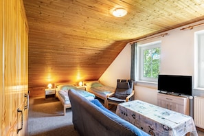A small, cozy room with wooden ceiling, two single beds, a chair, a table, and a TV. - Vacation at the uhlenhoff apartment bansmeer (Ihlow)