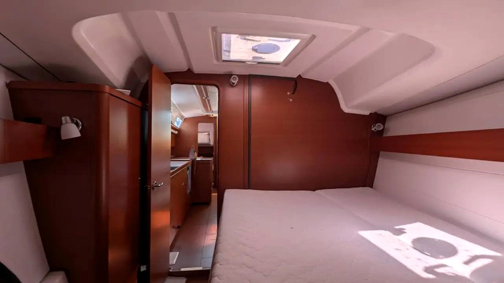 Un intérieur compact comprenant un lit, une armoire et une petite kitchenette.