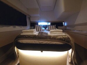 A private suite with a bed, pillows, and a TV screen.