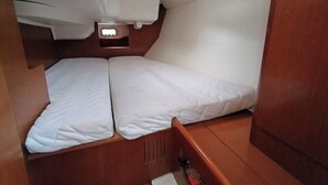 A compact cabin with two beds, a small window, and a wooden interior.