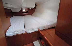 A compact cabin with two beds, a small window, and a wooden interior.