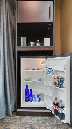 A hotel room with a built-in refrigerator, a minibar, and a small kitchen area. - Hotel Troy, Trademark Collection by Wyndham (Parsippany)