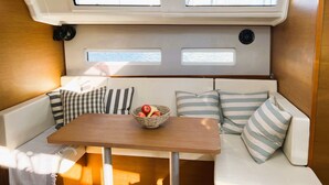 Ein gemütliches Interieur mit einem Holztisch, gestreiften Kissen und einer Obstschale.