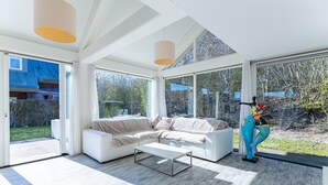 Ein modernes Wohnzimmer mit einem Ecksofa, einem Couchtisch und einer Skulptur.