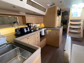 Una cocina compacta con un lavabo, una cafetera y un hervidor.