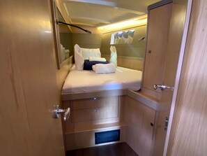 Una habitación compacta con una cama, un mueble pequeño y un calefactor empotrado.