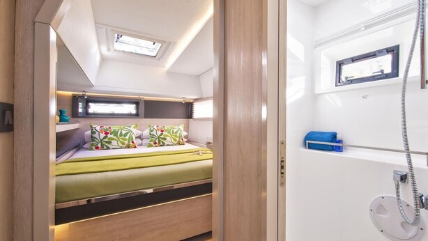 A compact RV interior with a bed, a small kitchenette, and a shower area. - Sun-Kissed Sailing Adventure in Isla de Mahe, Seychelles (Providence)