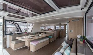 A modern interior with a central dining area, seating, and a view through large windows.