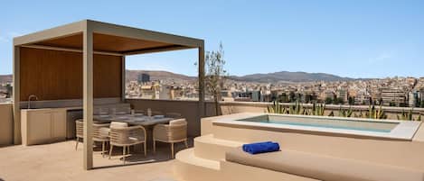 A rooftop terrace with a pool, seating area, and a bar.
