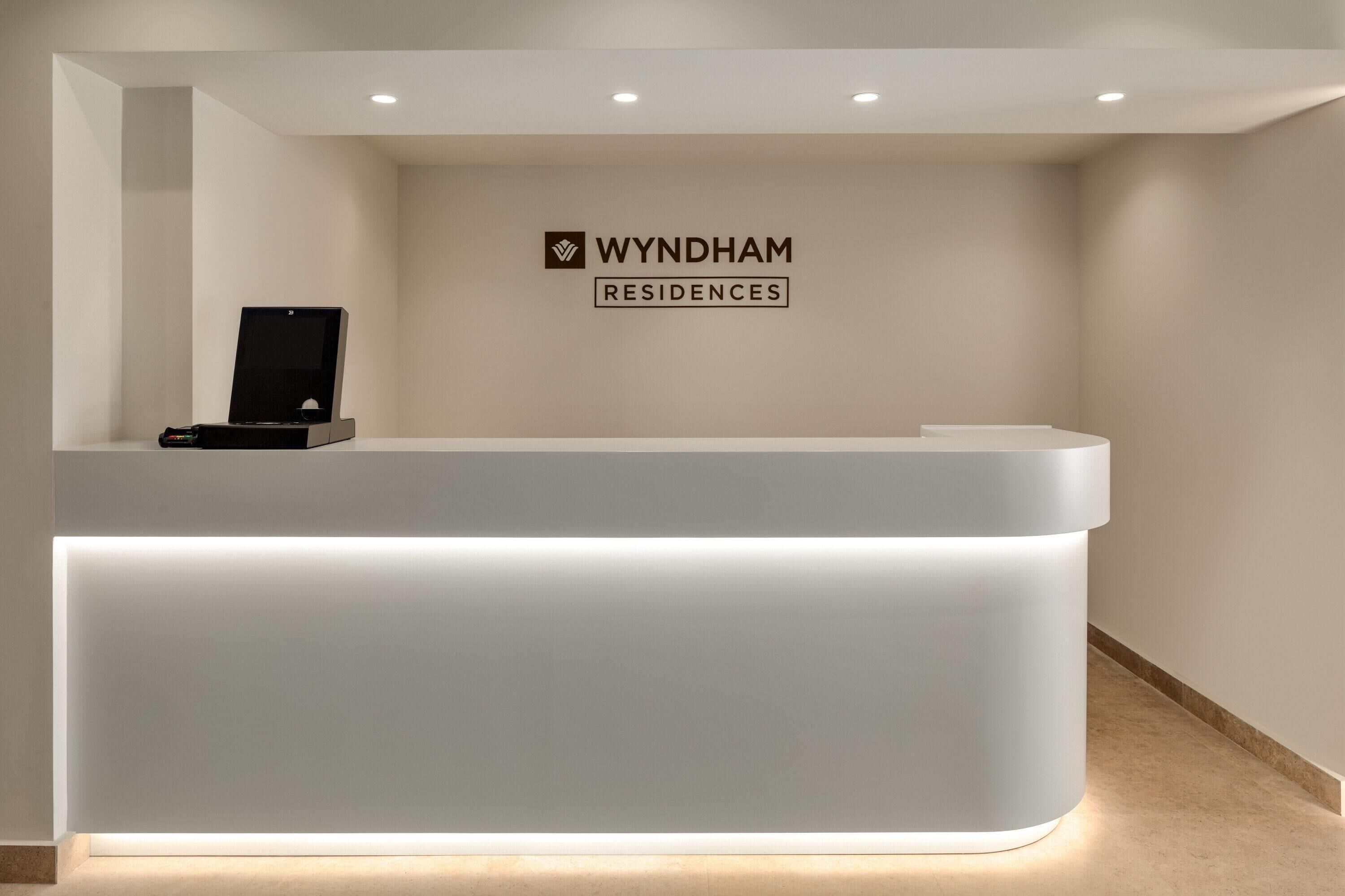 En reception med et moderne design, et logo over disken og en fladskærm til venstre.