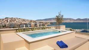 Una piscina en la azotea con vistas a un paisaje urbano y montañas.