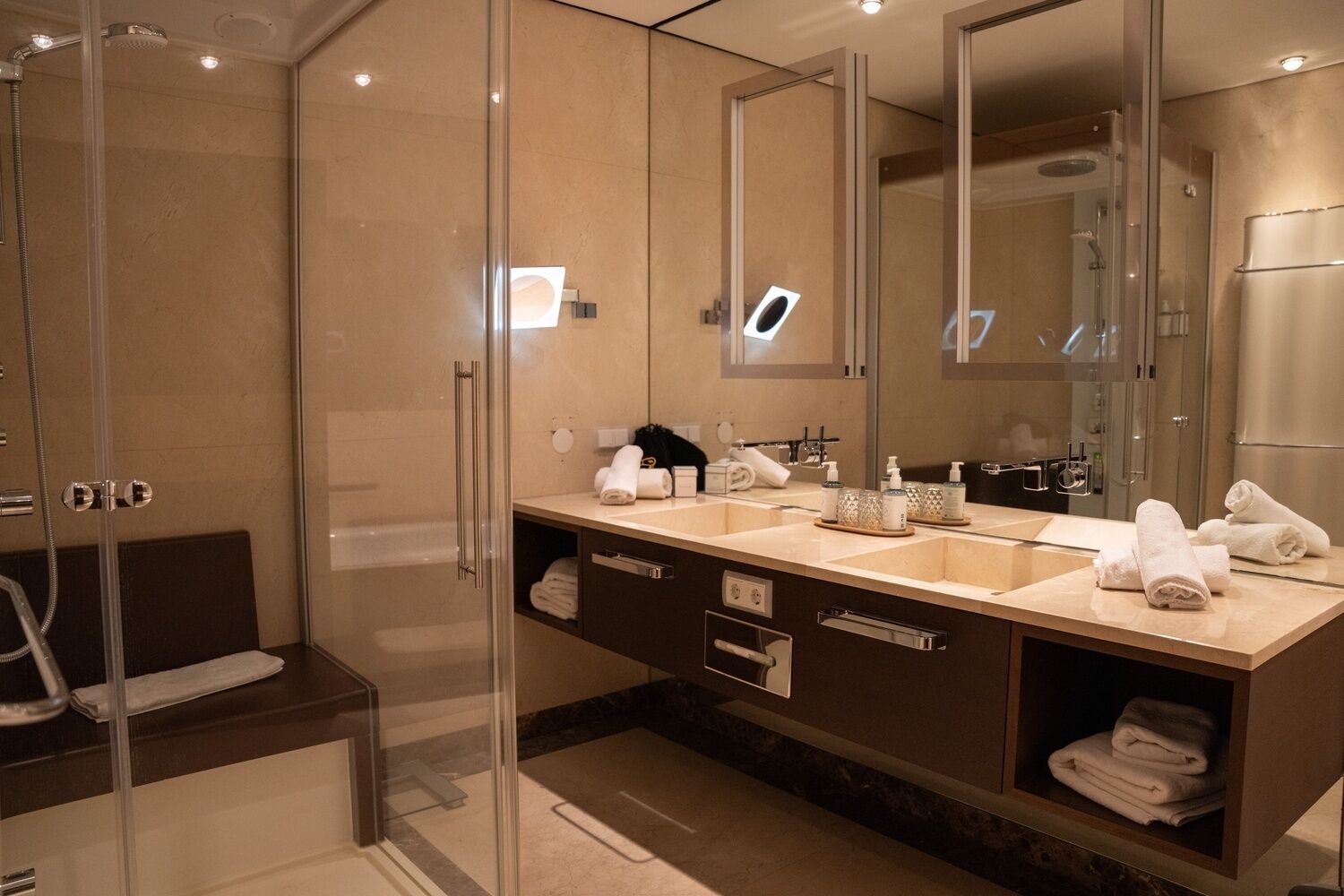 A modern bathroom with a glass shower enclosure, a double sink vanity, and a large mirror.