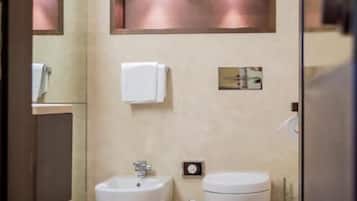 Een aparte badkuip en douche, een haardroger, pantoffels, handdoeken