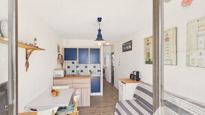 Cuina petita amb microones, rentapelats i armaris de fusta.