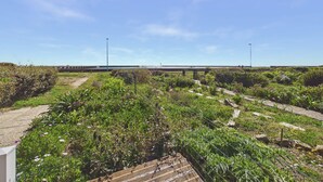 Un jardí amb un camí, una tanca i una construcció allunyada.
