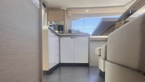 A compact kitchen with a built-in oven and microwave, a small countertop, and a view of the sky through a skylight. - Caribbean Dream: Sun-soaked Sailing Adventure from Tortola, Islas Vírgenes Británicas (Parham Town)