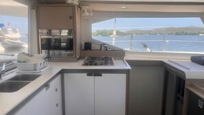 A compact galley with a stove, sink, and storage cabinets. - Caribbean Dream: Sun-soaked Sailing Adventure from Tortola, Islas Vírgenes Británicas (Parham Town)