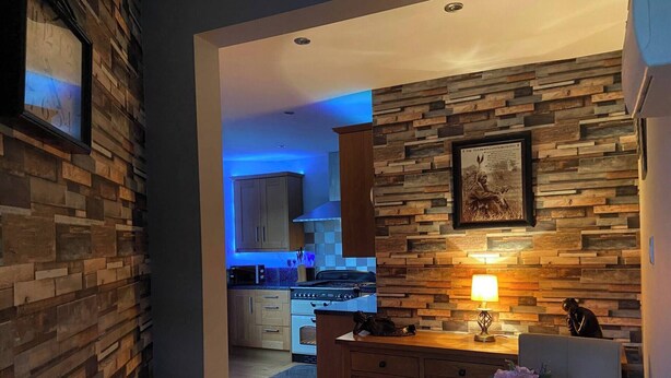 A modern kitchen with wooden accents, a dining area with a table and chairs, and a visible kitchen counter. - 1 Apartment Sleeps 2 (Sutton-in-Ashfield)