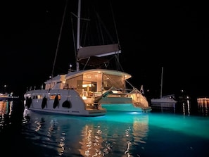 A yacht with a large deck, a swimming pool, and a well-lit interior. - Sun-Kissed Sailing Adventure in Islas Sarónicas (Alimos)