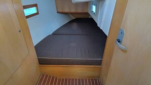 A compact interior with a bunk bed, a small window, and a door.