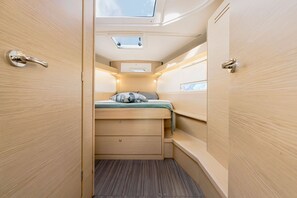 Ein gemütlicher Innenraum mit Bett, Stauraumschubladen und Dachfenstern.