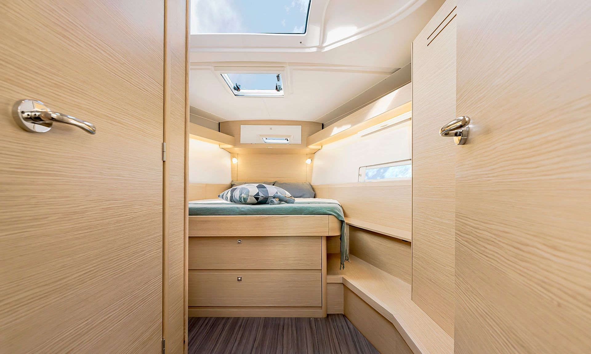 Un intérieur compact et bien éclairé, avec un lit superposé, des rangements intégrés et un puits de lumière.