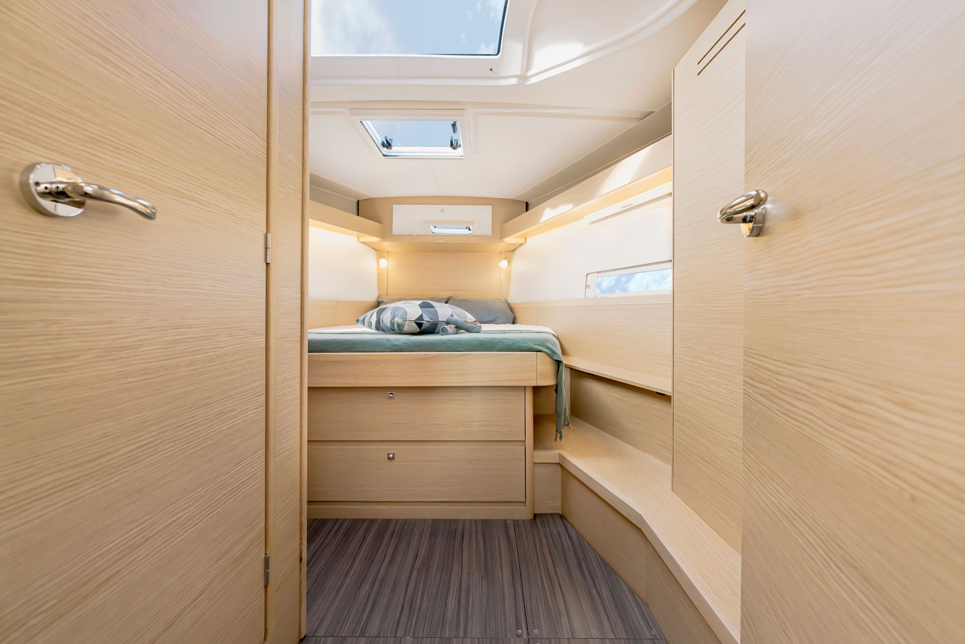Un interior compacto con cama, cajones para guardar objetos y tragaluces.