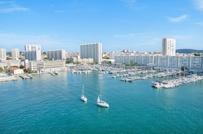 Un port de plaisance où sont amarrés de nombreux bateaux, entouré de grands immeubles.