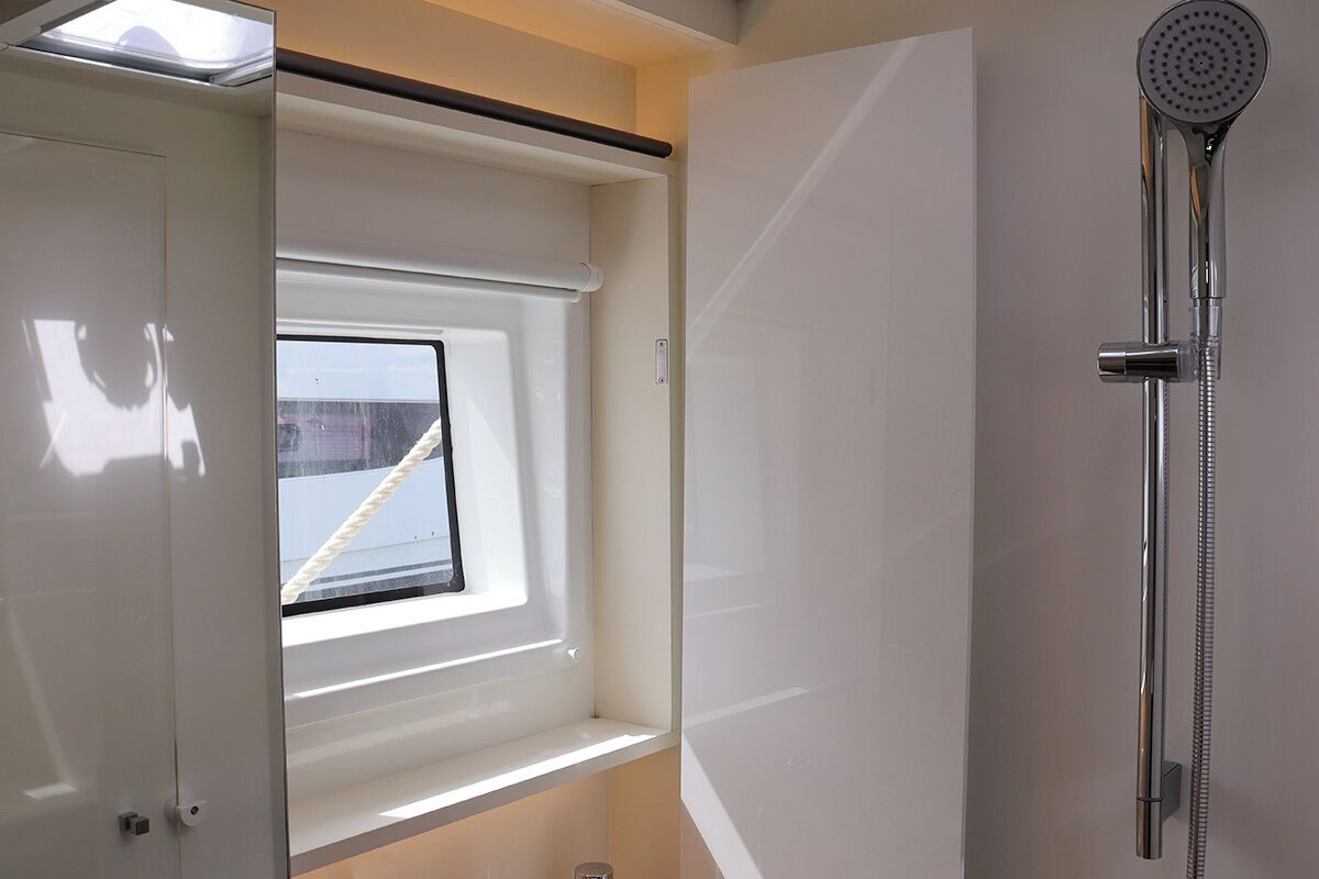 Un bagno moderno con finestra a lucernario, doccia e finestra.