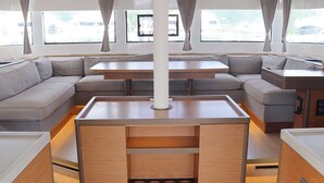 A modern interior with a sofa, a dining table, and a central column. - Caribbean Dream: Sun-soaked Sailing Adventure from Tortola, Islas Vírgenes Británicas (Road Town)